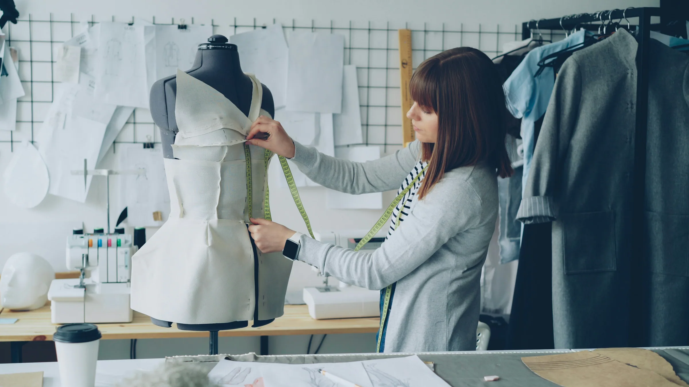 Fashion designers measuring patterns together in a working studio