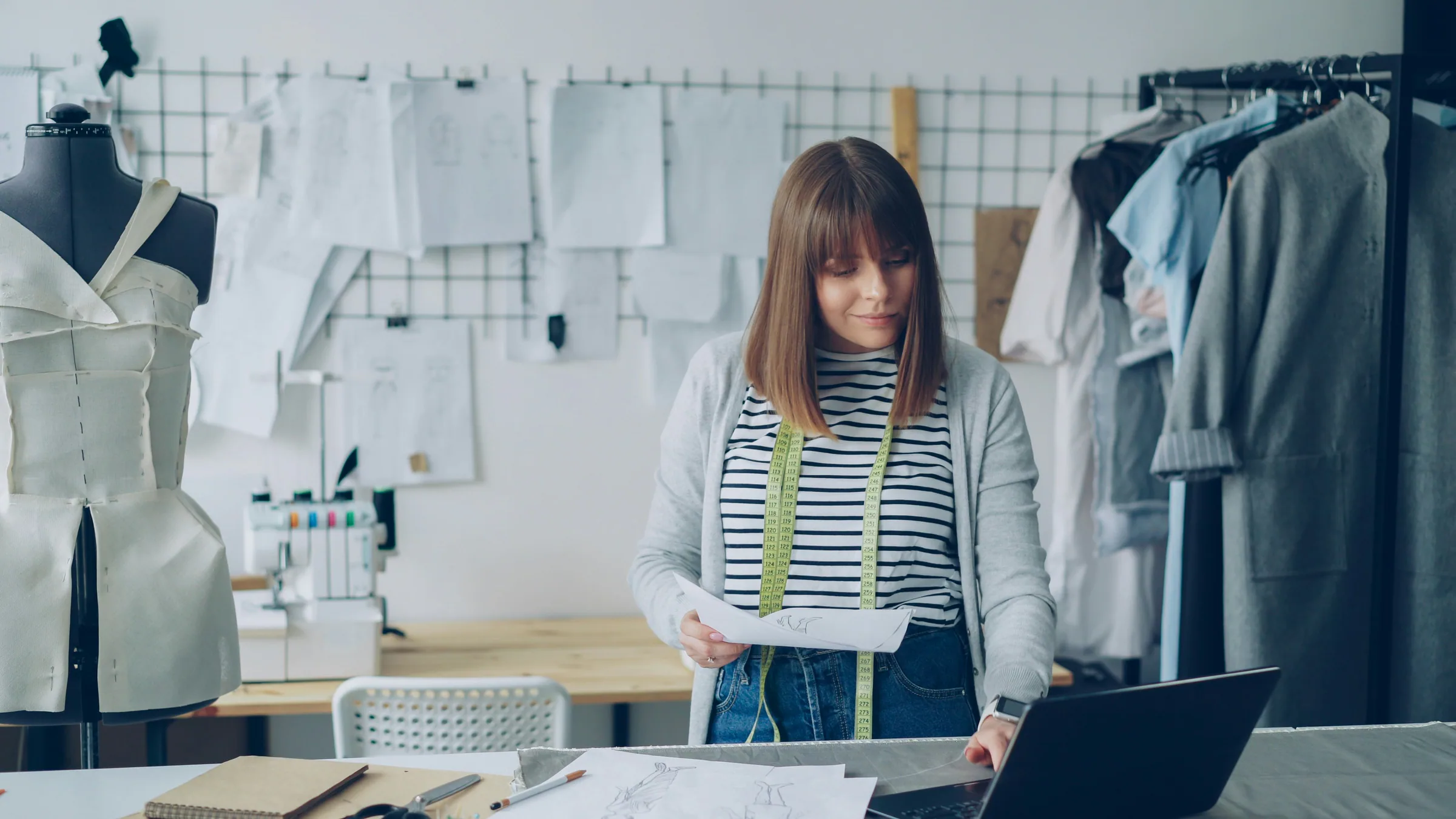 Fashion designer reviewing sketches on a laptop