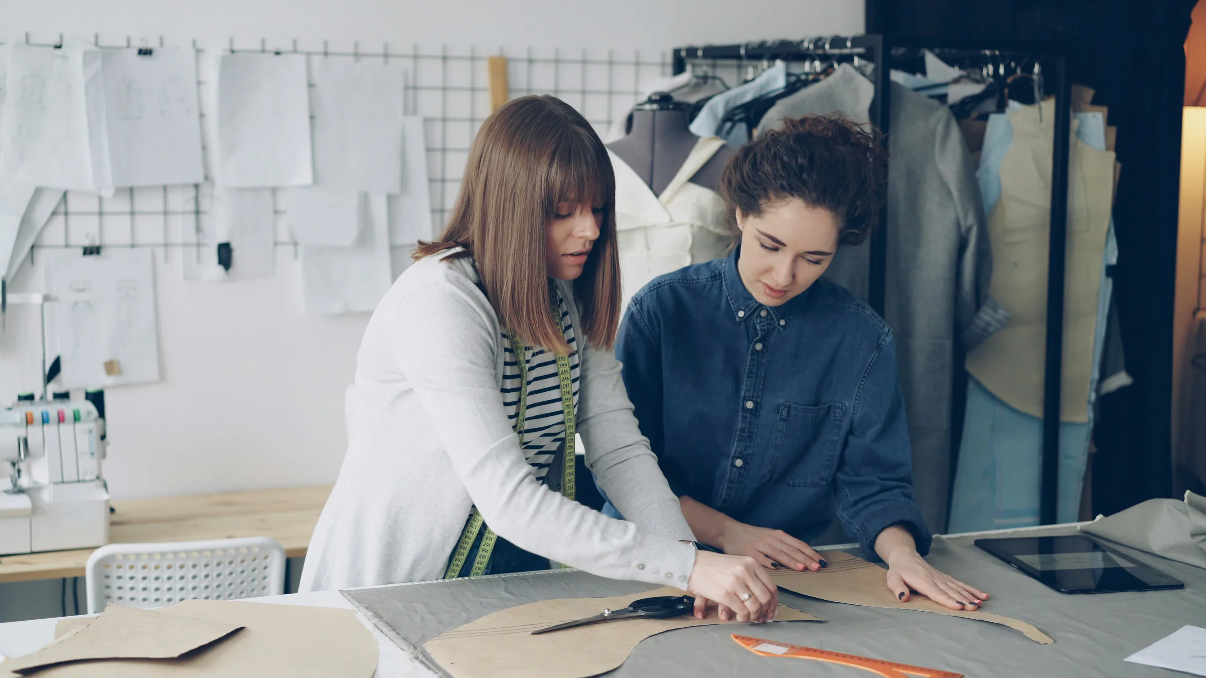 Fashion designers measuring patterns together in a working studio